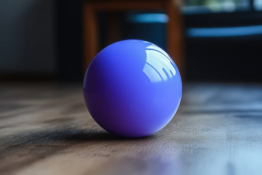 A purple ball sitting on a wooden floor photo