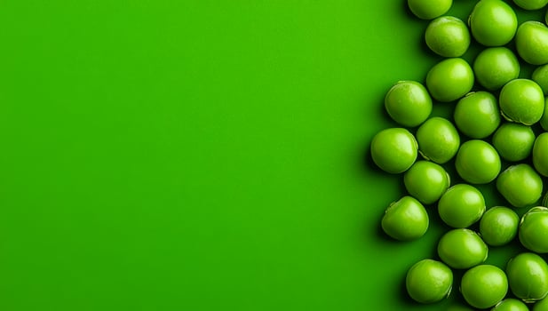 Vibrant fresh green peas. Fresh green peas are neatly arranged on a vivid green surface, highlighting their color and freshness. photo