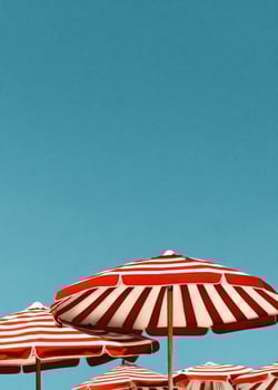 Colorful Striped Umbrellas Provide Shade at a Sunny Beach Location on a Clear Day. photo