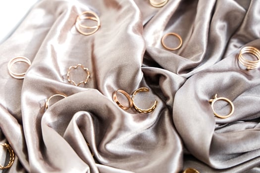 Elegant gold rings displayed on smooth satin fabric for a chic presentation photo