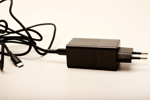 Smartphone charger with cable on white. A new charger for gadgets with a wire. USB charging with a wire. photo