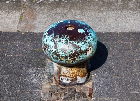 Old rusty mooring bollard on a dock photo