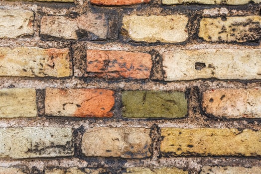 Colorful old brick wall showing weathering and aging effects photo