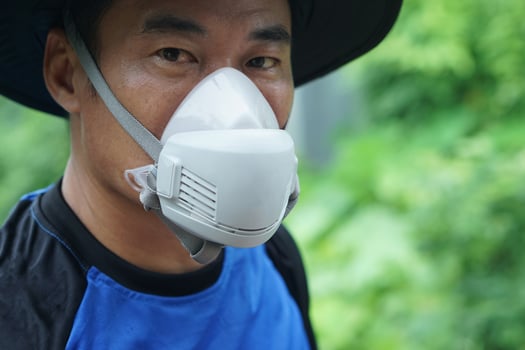 A protective face mask used by farmer during pesticide or chemical spraying. The mask helps prevent inhalation of toxic substances. Concept safety and health in agricultural environments. photo