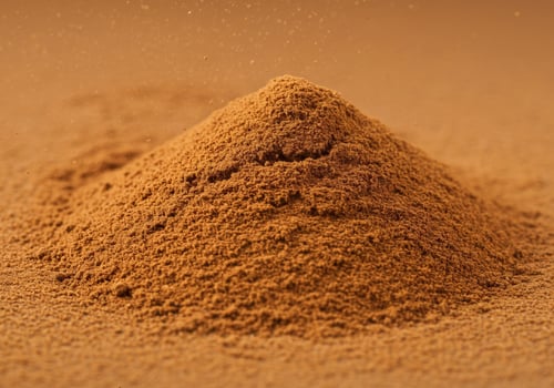 A pile of fresh ground cinnamon with a soft background. photo