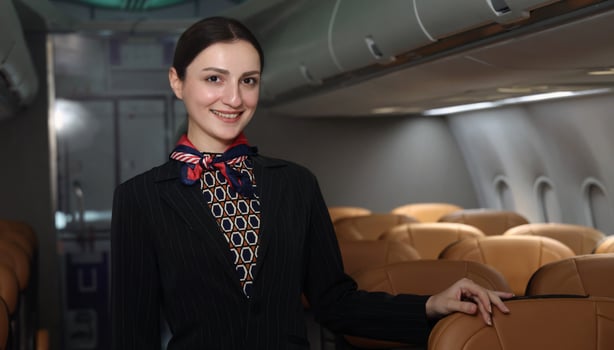 Air hostess. Smiling flight attendant in uniform welcomes and guides passengers aboard a modern airplane. Friendly airline staff providing professional service and comfortable travel flight experience photo