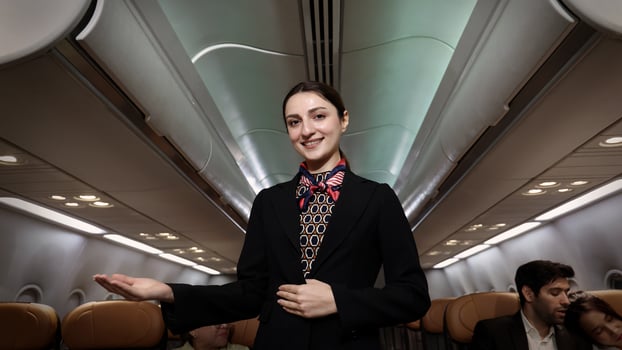 Smiling. flight attendant in uniform welcomes and guides passengers aboard a modern airplane. photo