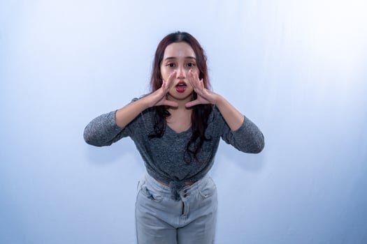 Asian Indonesian woman wearing a long gray shirt is screaming photo