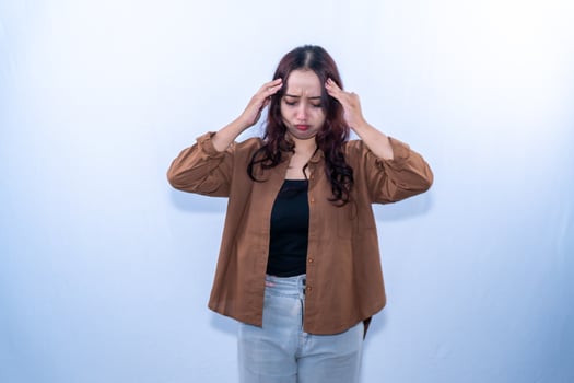 Asian Indonesian woman wearing brown clothes is confused or stressed photo
