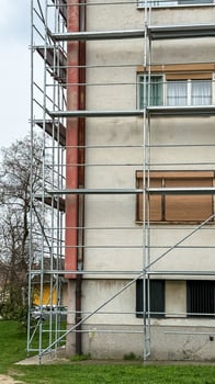 Sturdy scaffolding embraces the pale facade, whispering tales of urban renewal and Festivus preparations, dreams scaffolded anew photo