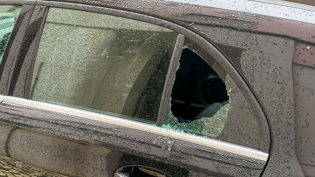 Shattered car window glistens in twilight drizzle, urban silence, echo of mischief, Mischief Night or Solitary Reflection Day photo