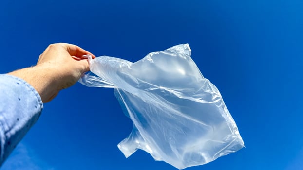 A translucent plastic bag dances like an urban ghost in azure skies, celebrating Earth Day and International Trash Picnic photo