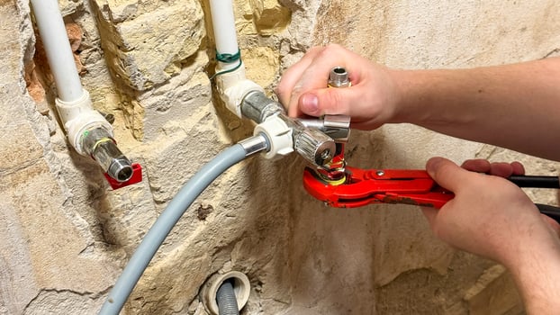 Urgent repair hands on rustic pipes, echoing Home Improvement Months hidden alchemy, tactile craftsmanship, unspoken plumbing narratives photo