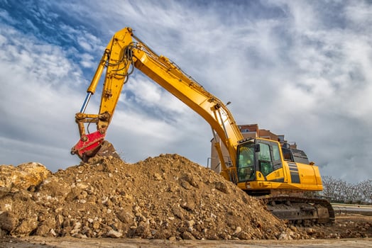 A stopping yellow excavator, at a construction site photo