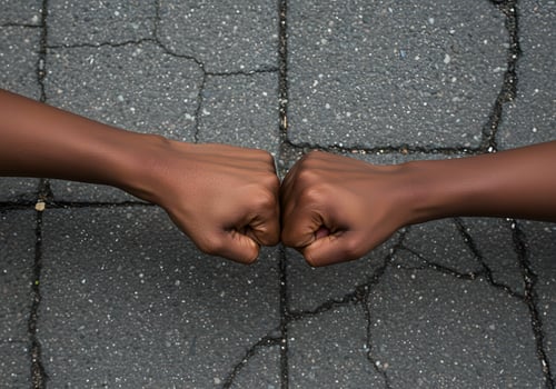 Clenched fists on cracked pavement photo