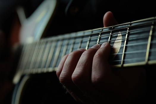 Musician playing acoustic guitar, close-up on fretboard and hand photo