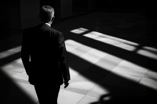 Businessman walking in dark corporate building with dramatic lighting photo