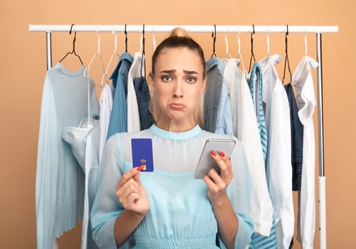 Debt, Failed Transaction, Lack Of Money. Portrait of sad upset female customer holding credit card with limit and using mobile phone, having problems with purchase in store and online payment photo