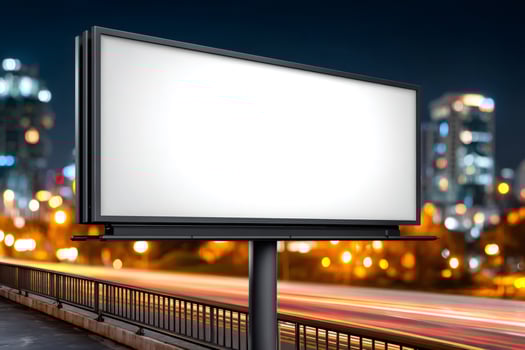 Blank billboard by road with city lights at night showing light trails photo