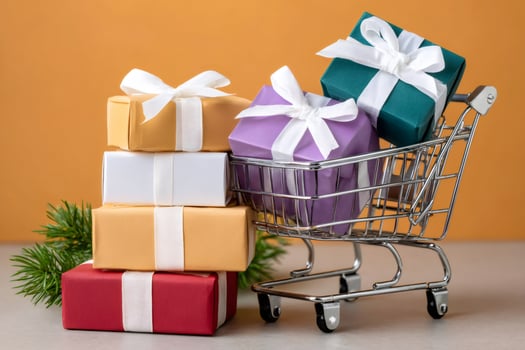 Shopping cart carrying Christmas gifts and stack of colorful presents with white ribbons photo