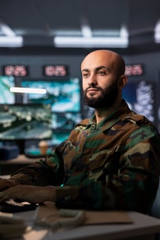 Air force combat control officer performing tactical level surveillance in headquarters, using satellite equipment. Military expert using radar technology to search for potential assault zones photo