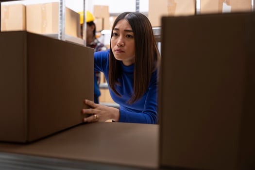 Asian woman preparing custom orders in storage room with parcels and products. Local shipping and retail fulfillment are part of daily business operations in small scale logistics center. photo