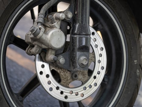 Motorcycle brake system close-up urban road daylight detail engineering analysis photo