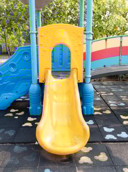 Children playing yellow slide at playground outdoor fun vibrant environment bird's eye view photo