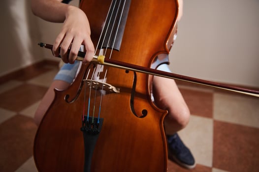 Close-Up of Student Playing a Cello in a Music Practice Setting photo