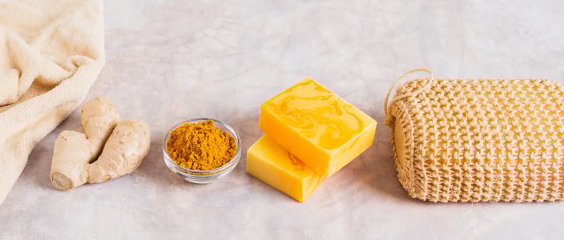 Homemade natural turmeric soap and ingredients on the table web banner photo
