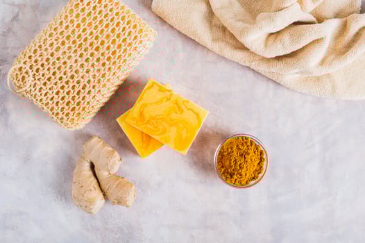 Homemade natural turmeric soap and ingredients on the table top view photo
