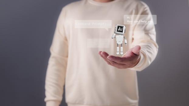 A person holding their hand out with a miniature white robot displaying AI and chat bubbles, Artificial intelligence, conversational AI, digital assistance, future technological interaction. photo