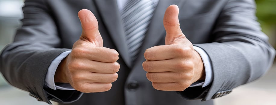 A man in a suit and tie giving a thumbs up photo