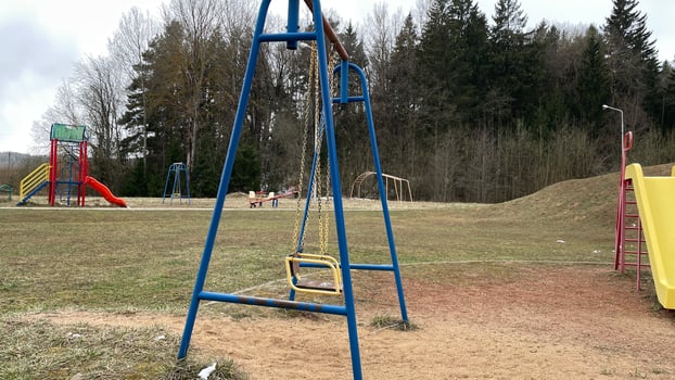 Blue swings on the playground. Depressive autumn landscape in rainy weather. photo