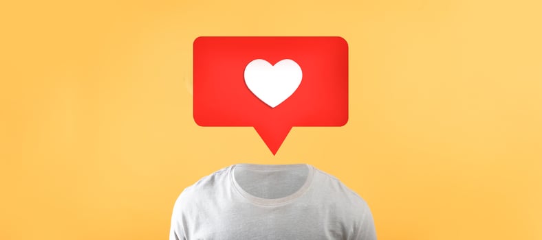A unique representation showcases a torso in a plain shirt with a red speech bubble above it. The speech bubble contains a white heart symbol, emphasizing social media connections and engagement. photo