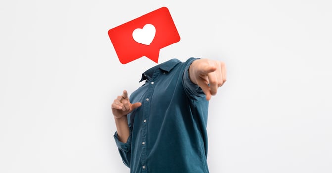 A person stands against a plain background, pointing confidently while a heart icon hovers above where their head would be. This playful representation captures the essence of social media engagement. photo