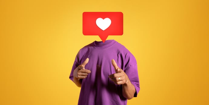 A person dressed in a purple shirt points towards the viewer, their head replaced with a large heart icon. The bright yellow background emphasizes the theme of social media positivity and interaction. photo