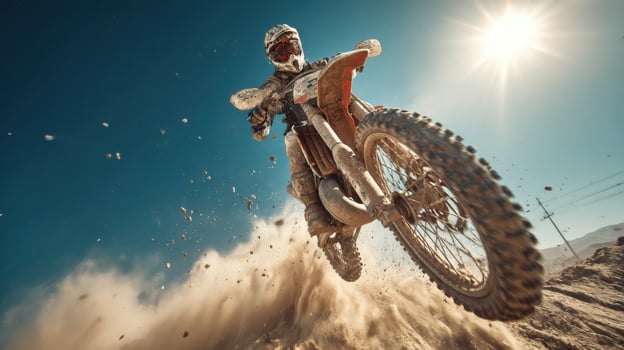 Motocross rider riding dirt bike on sand photo