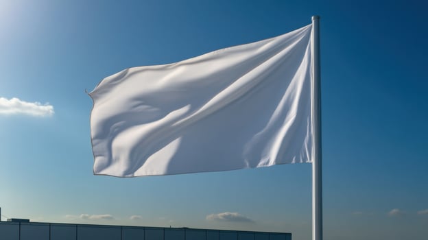 A white flag flutters gently atop a tall pole, contrasting with the vibrant blue sky filled with a few wispy clouds. Sunlight brightens the urban landscape below photo