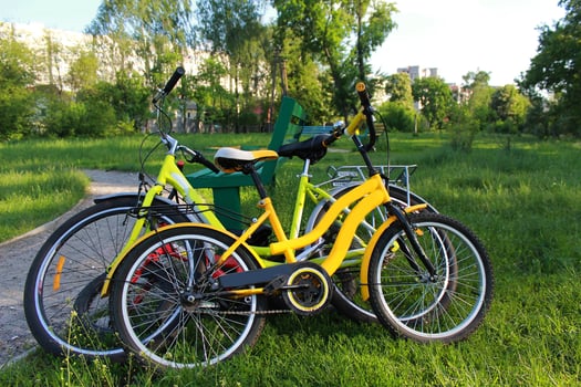 Three town bikes leaned in a bench in the city park. photo