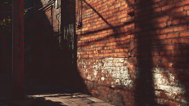 Old brick wall in a dark alleyway with sunlight casting shadows creating a vintage aesthetic photo