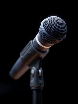 A microphone on stage with black background. photo