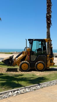 Yellow Backhoe Loader at Coastal Construction Site photo