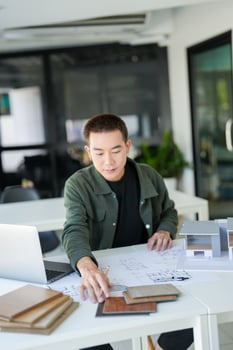 a business man sitting at a table with a laptop and papers photo