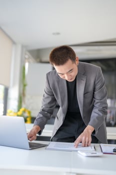 a businessman in a suit is working on a laptop photo