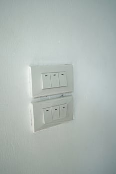 Close up indoor light switch panel on white wall photo