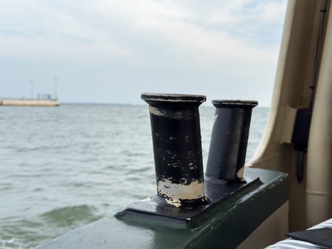 Weathered boat cleats on deck overlooking calm sea photo
