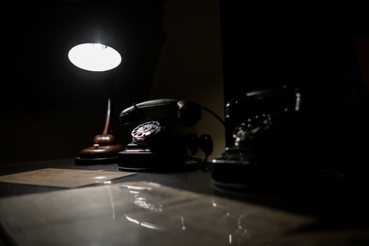 Old-fashioned Telephones and a Lamp Create a Nostalgic Atmosphere in a Dimly Lit Room, Showcasing Vintage Communication Tools photo