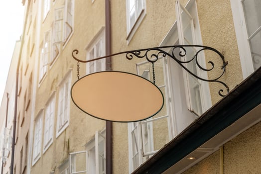 Decorative oval signage on historic building wall, suitable for boutique store visuals, cafe logo templates, or artisan advertising graphics photo