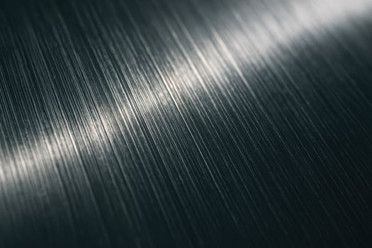 Textured brushed metal surface with fine vertical lines and light reflection photo